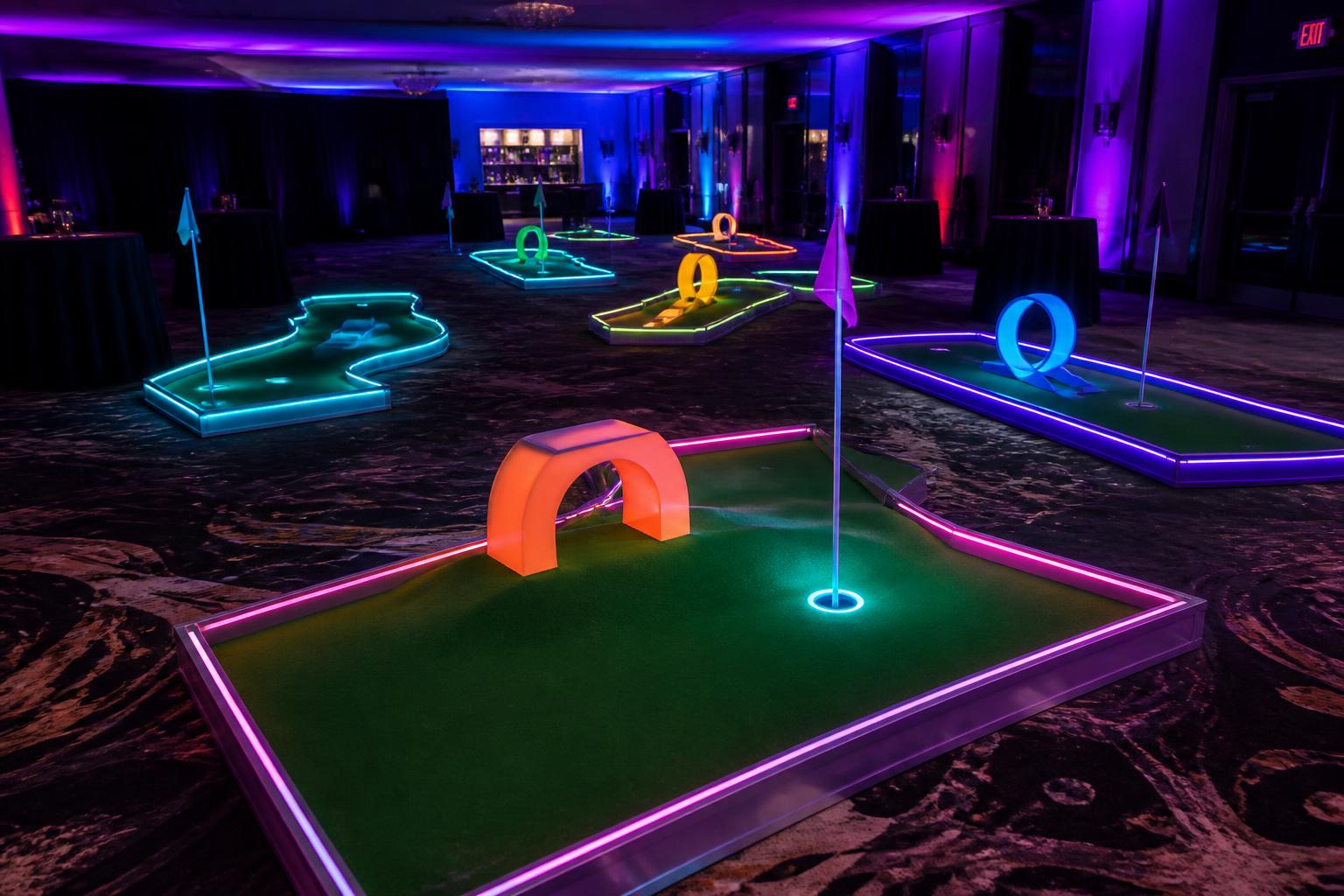 Glow-in-the-dark mini golf course set up indoors at an evening event